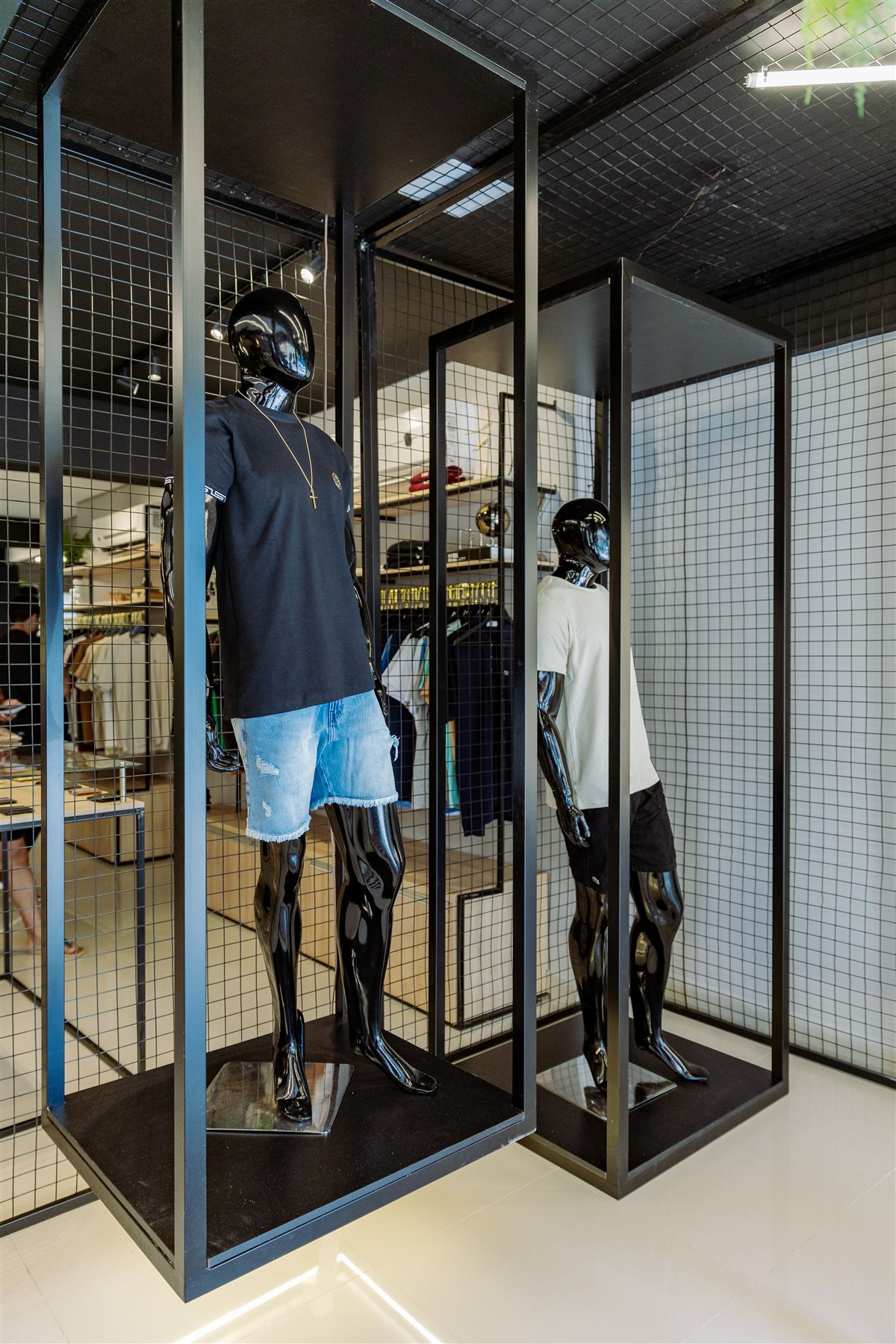 Vitrine da loja Elegance Outlet com manequins em estrutura de grade metálica