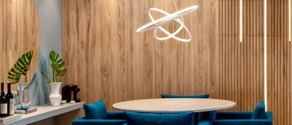 Sala de jantar com painel amadeirado, mesa oval e estofado azul