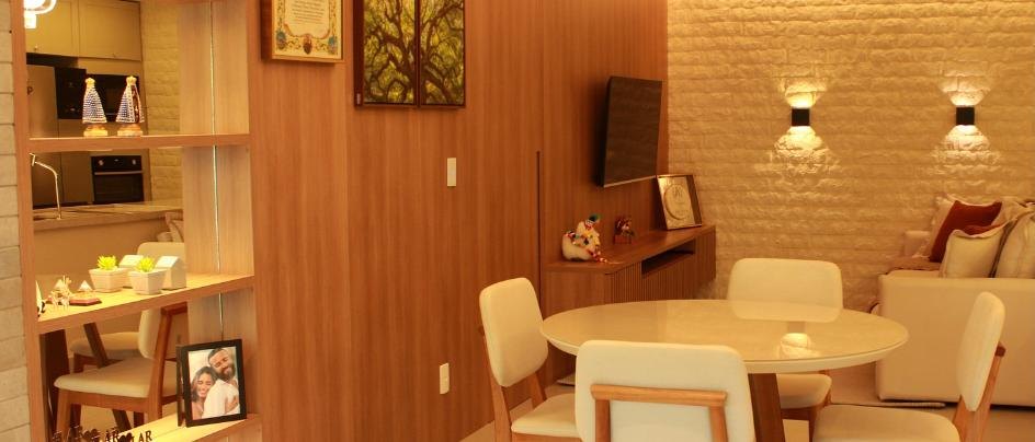Sala de jantar integrada com painel amadeirado e parede de tijolinho