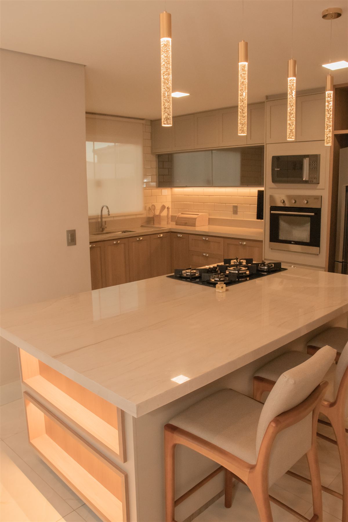 Cozinha planejada com ilha central e pendentes