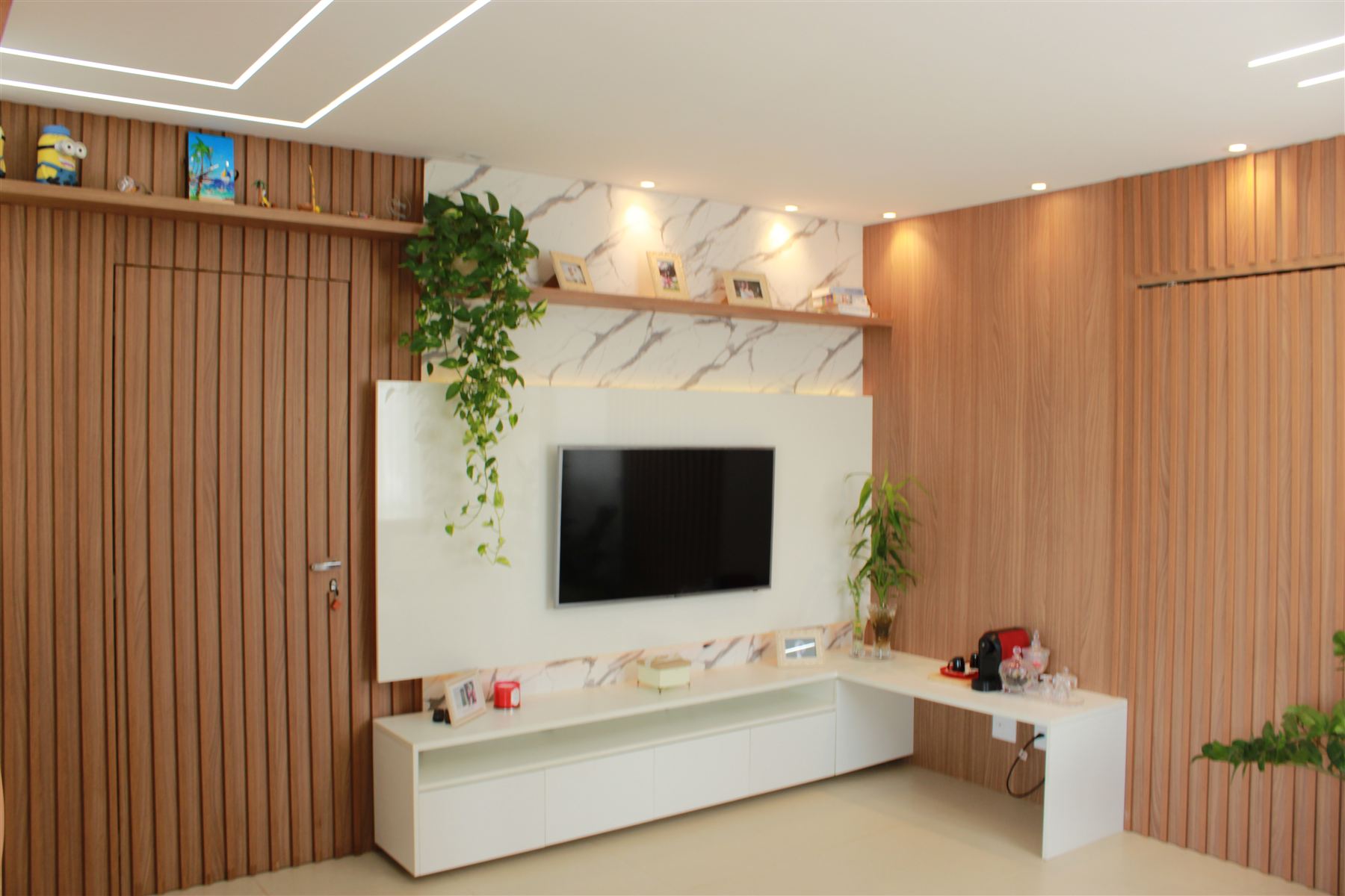 Sala de estar com painel de mármore e TV embutida